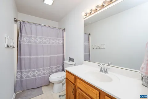 a bathroom with a granite countertop sink toilet a mirror and shower