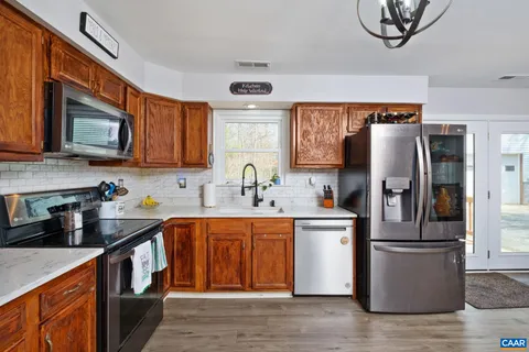 a kitchen with stainless steel appliances granite countertop a refrigerator a stove top oven a sink and dishwasher