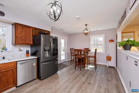a view of kitchen with sink microwave refrigerator and dining table
