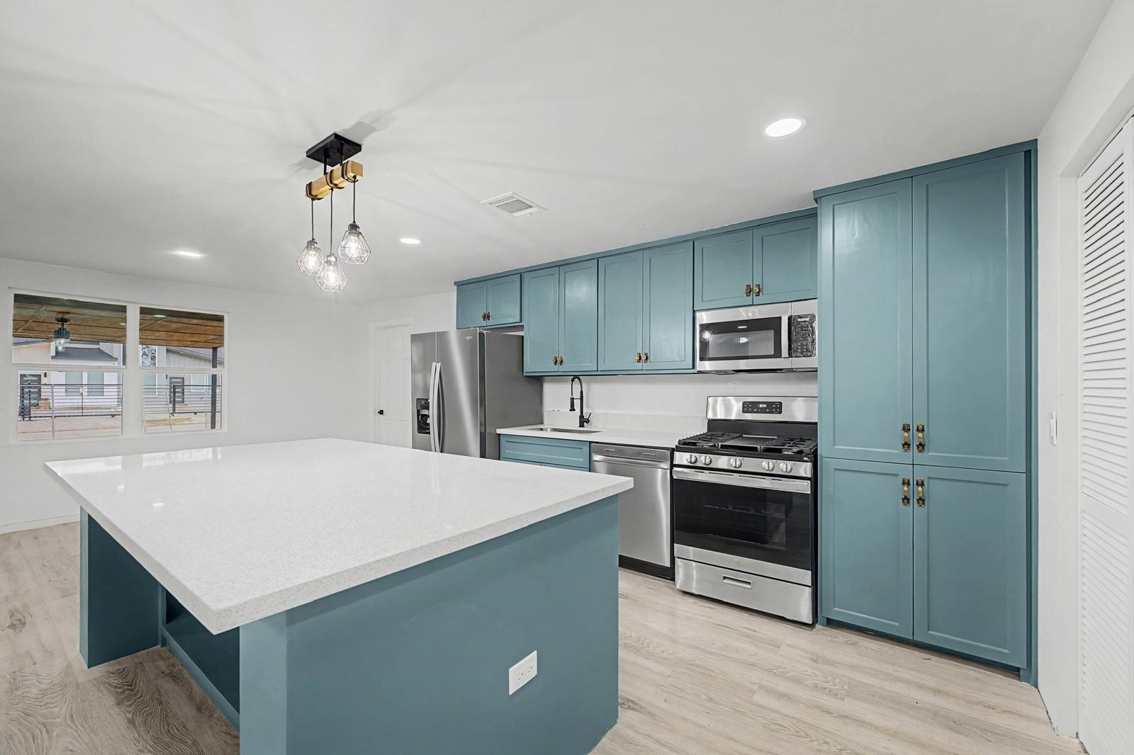 5719 Southwind Street Houston, TX 77033 - Photo 5 of 15 a kitchen with a stove a sink and a refrigerator
