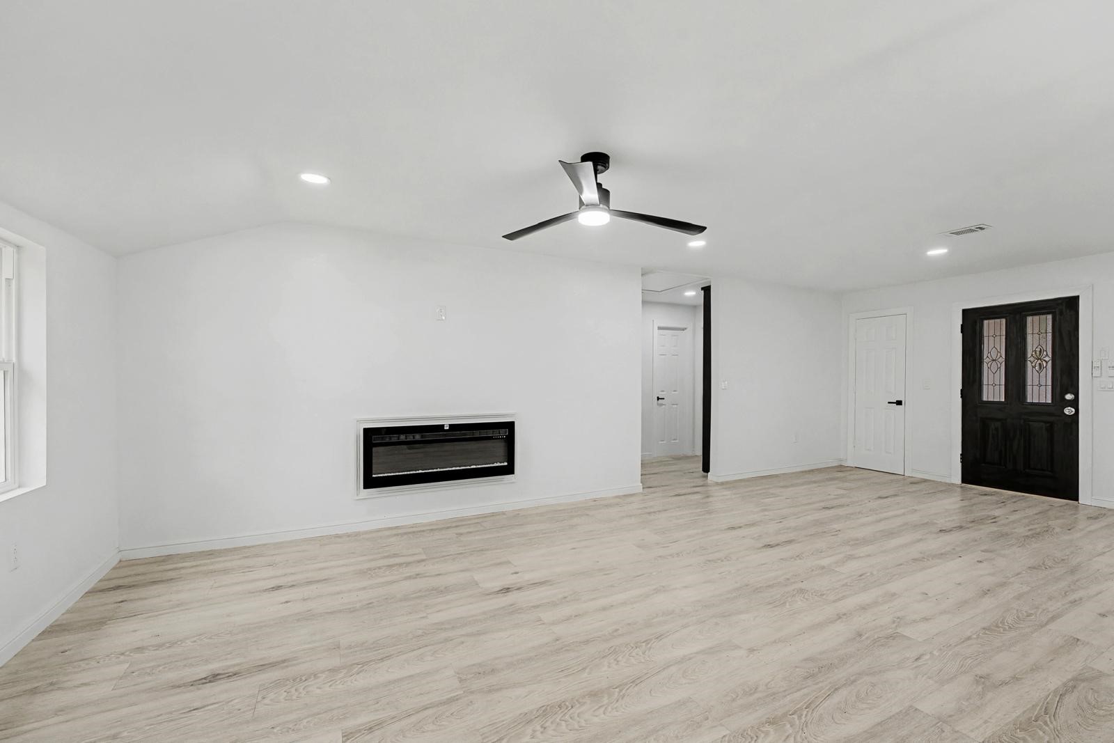 5719 Southwind Street Houston, TX 77033 - Photo 7 of 15 a view of empty room with wooden floor and ceiling fan