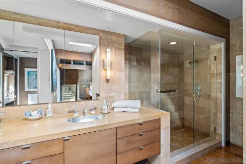 a bathroom with a shower sink vanity granite and mirror
