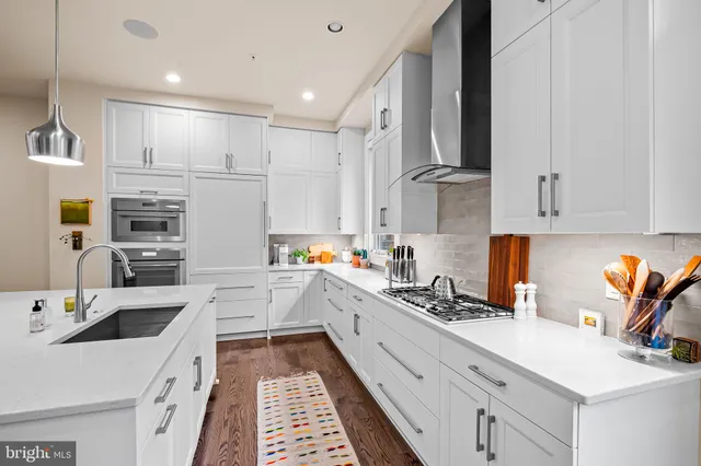 a kitchen with stainless steel appliances kitchen island granite countertop a sink and cabinets