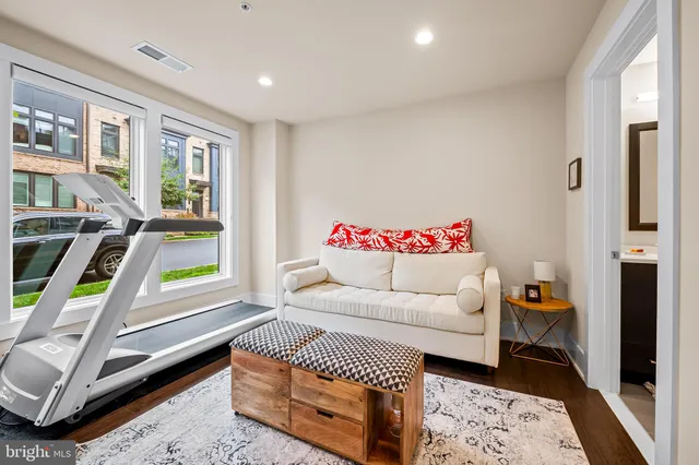 a living room with furniture flat screen tv and a large window
