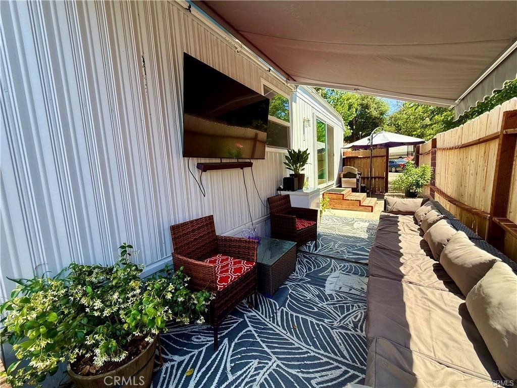 a living room with patio furniture and a flat screen tv