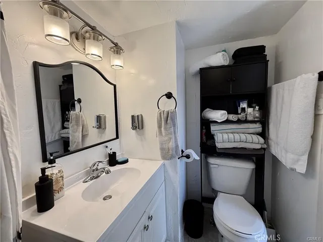 a bathroom with a sink vanity mirror and toilet
