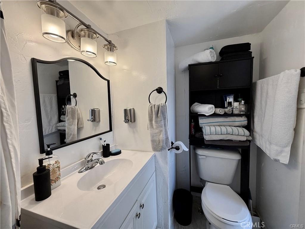 7665 Cache Creek Way Clearlake, CA 95422 - Photo 18 of 41 a bathroom with a sink vanity mirror and toilet
