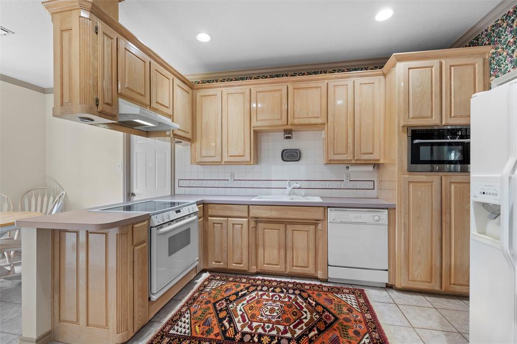 2114 Trace Ridge Drive Weatherford, TX 76087 - Photo 5 of 14 a kitchen with stainless steel appliances granite countertop a stove a sink and a refrigerator