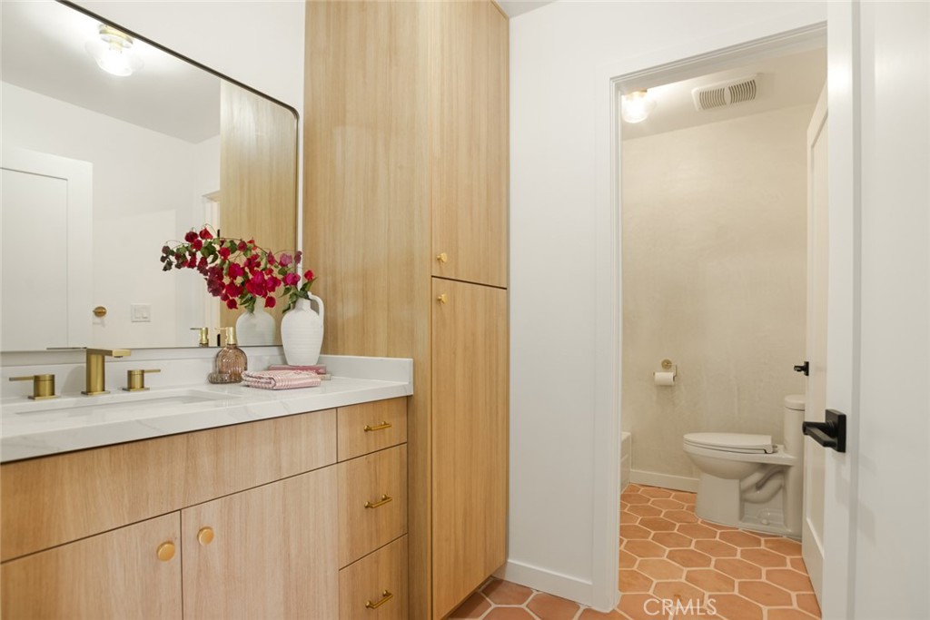 334 Gladys Avenue, Unit 305 Long Beach, CA 90814 - Photo 13 of 26 a bathroom with a sink a toilet and a mirror