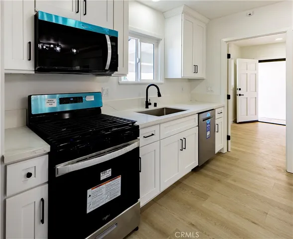 a kitchen with stainless steel appliances granite countertop a refrigerator sink and microwave