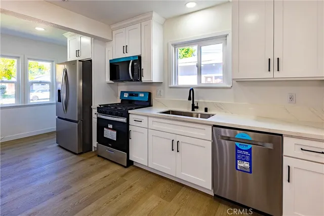 a kitchen with stainless steel appliances a microwave sink and refrigerator