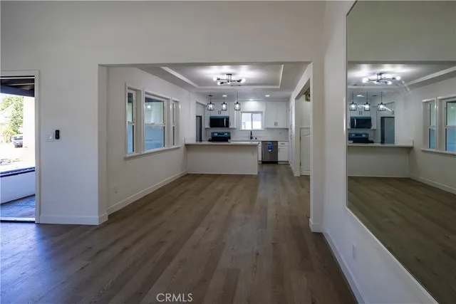 a large white kitchen with a window and stainless steel appliances