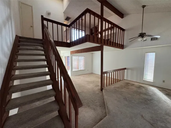 a view of staircase with railing and white walls