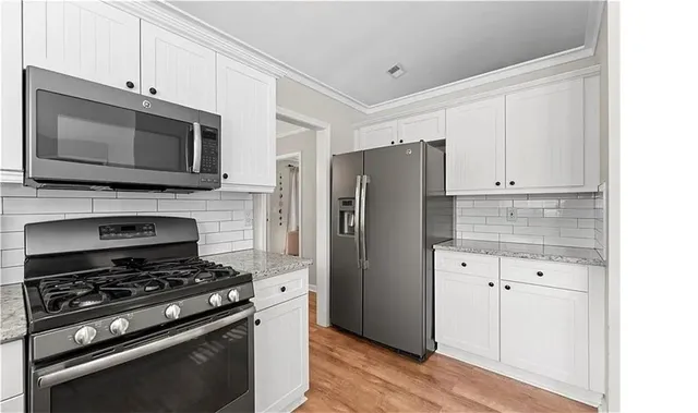 a kitchen with granite countertop a stove and a microwave