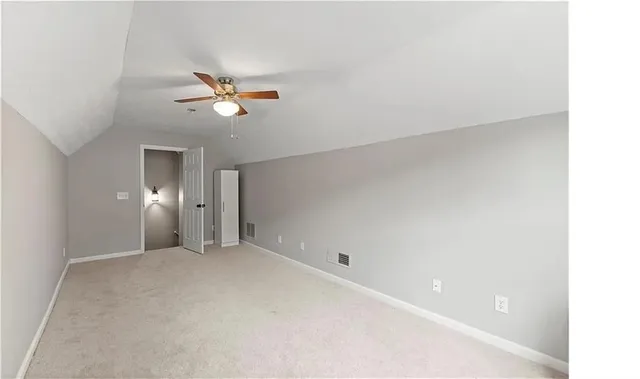 an empty room with a window and a ceiling fan