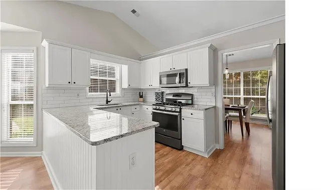 a kitchen with a stove a sink and a microwave