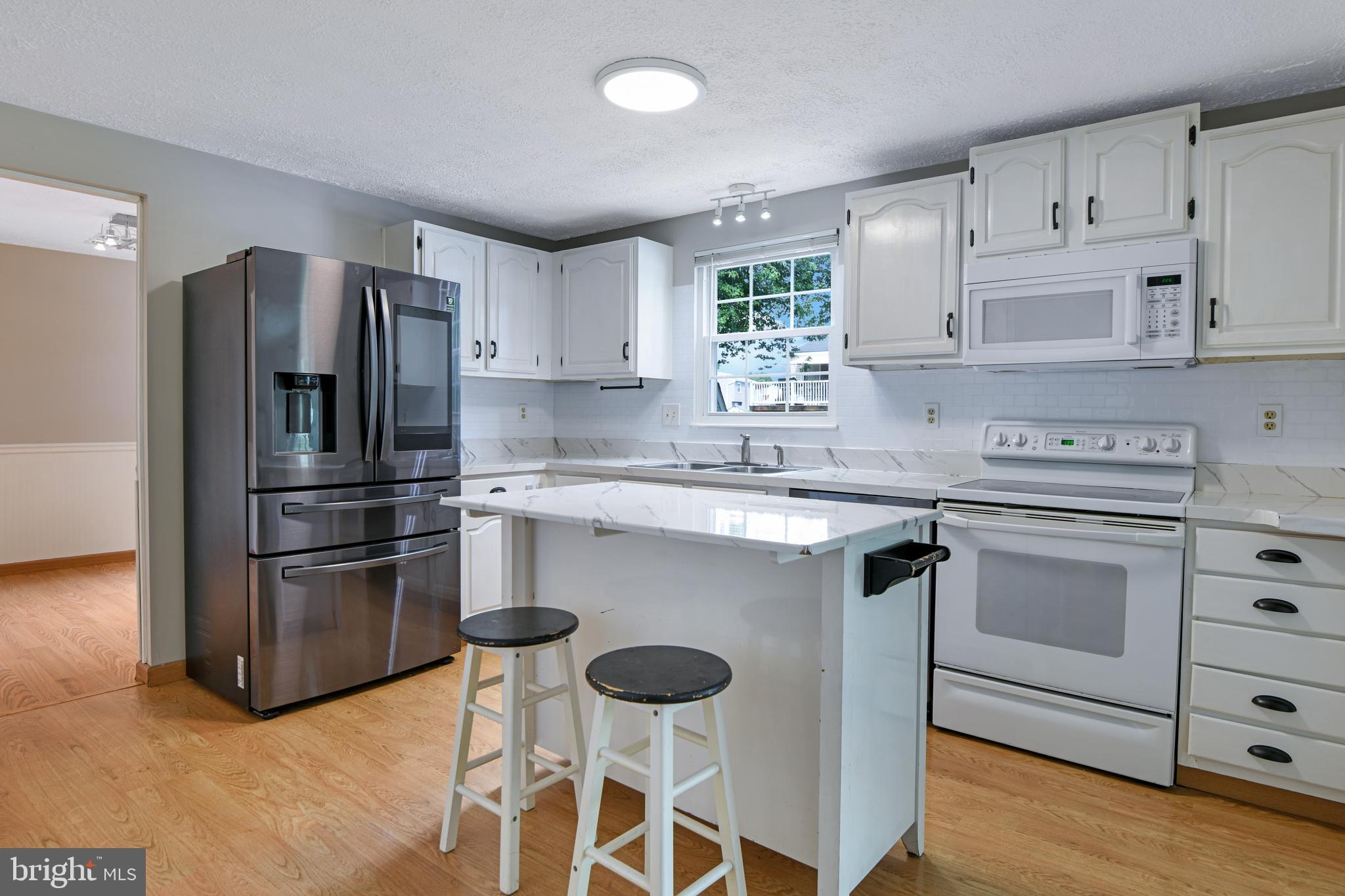 1824 Lawnview Drive Frederick, MD 21702 - Photo 3 of 21 a kitchen with stainless steel appliances granite countertop a stove a refrigerator and a sink with wooden floor