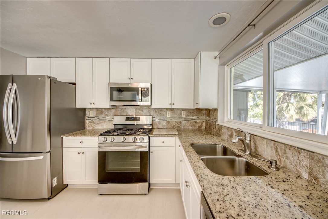 12262 Boat Shell Drive Matlacha Isles, FL 33991 - Photo 18 of 39 a kitchen with a stove a sink and a refrigerator