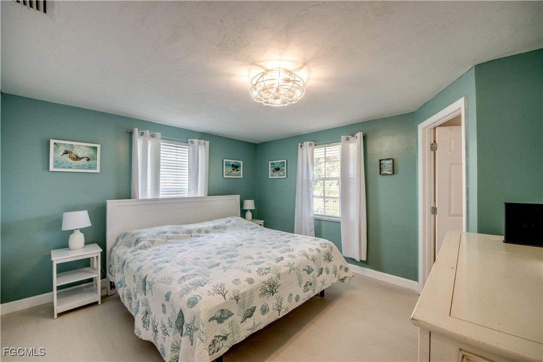 12262 Boat Shell Drive Matlacha Isles, FL 33991 - Photo 22 of 39 a bedroom with a bed and a chandelier