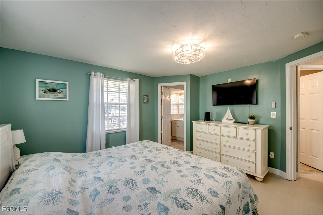 12262 Boat Shell Drive Matlacha Isles, FL 33991 - Photo 23 of 39 a bedroom with a large bed and a flat screen tv