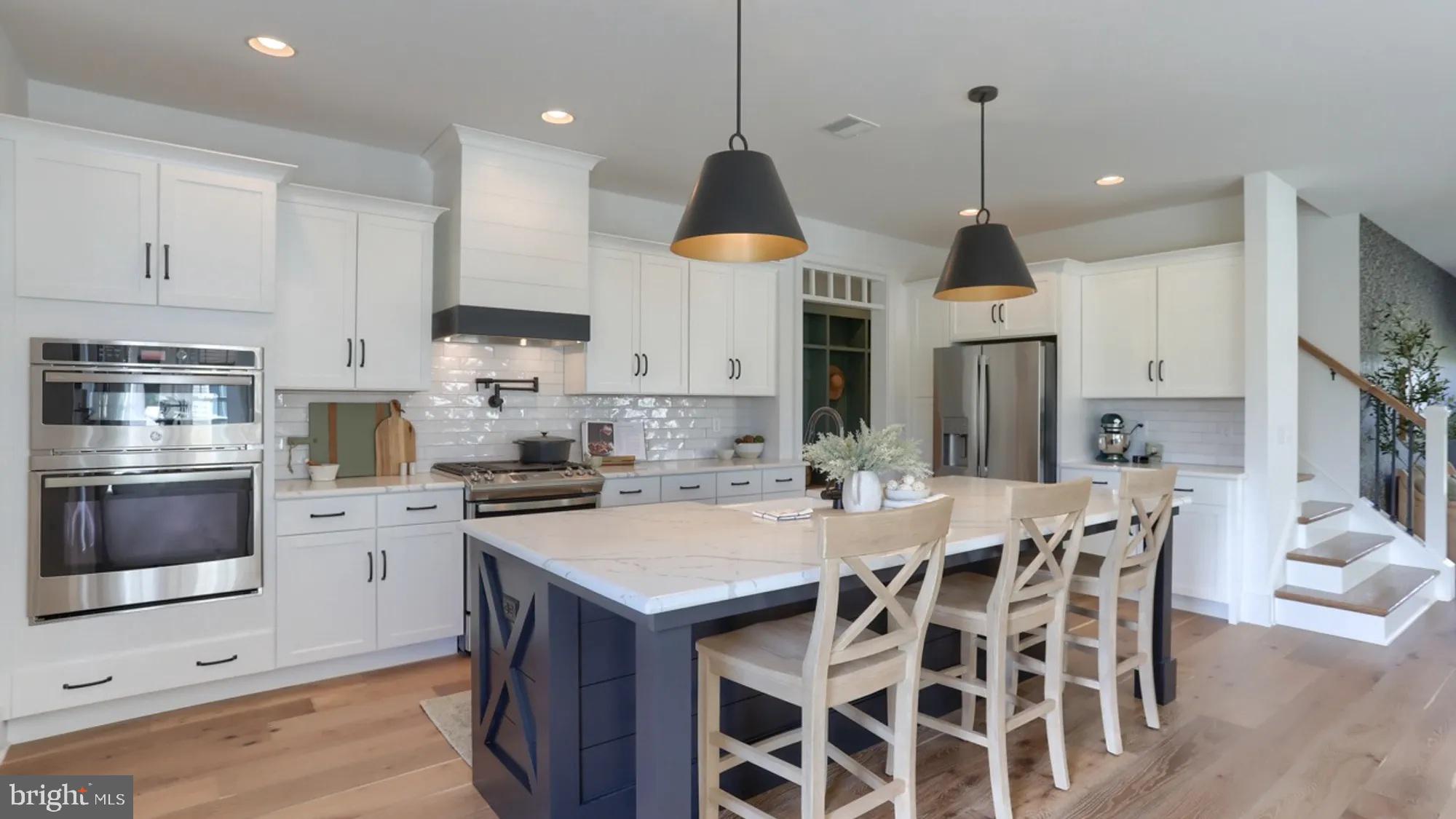 100 Flora Boulevard Lebanon, PA 17042 - Photo 9 of 24 a kitchen with granite countertop a stove a sink a kitchen island with a cabinets and wooden floor