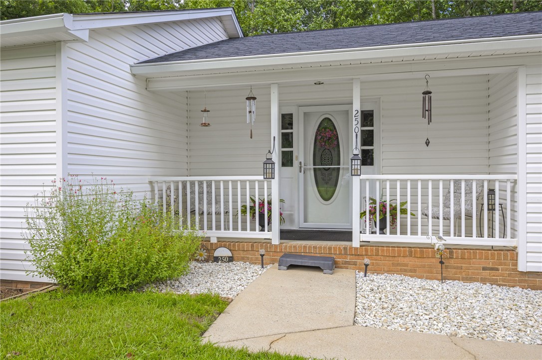 250 Rockcrest Road Cleveland, SC 29635 - Photo 7 of 37 A welcoming front porch features white vinyl siding and a charming walkway, creating appealing curb appeal.