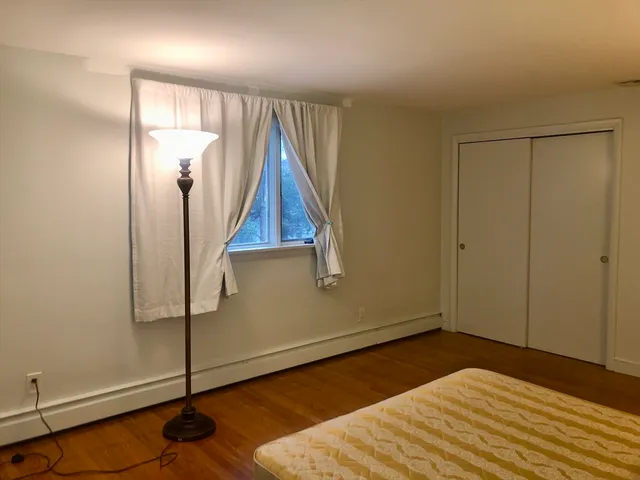 a bedroom with a bed and a wooden floor