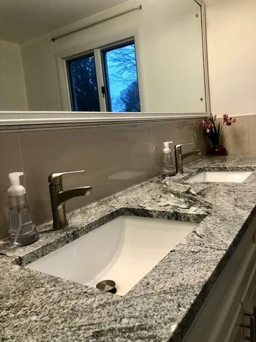 a bathroom with a granite countertop sink and a mirror