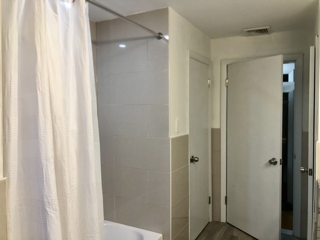 15 Sycamore Road Wakefield, MA 01880 - Photo 16 of 39 a bathroom with a shower and a curtain