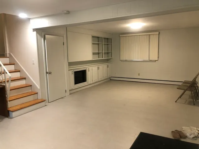 a view of a livingroom with wooden floor and staircase