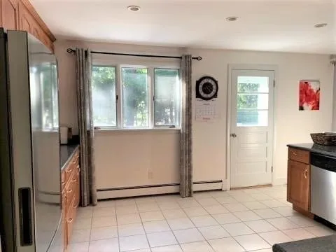 a view of a refrigerator in kitchen and a window
