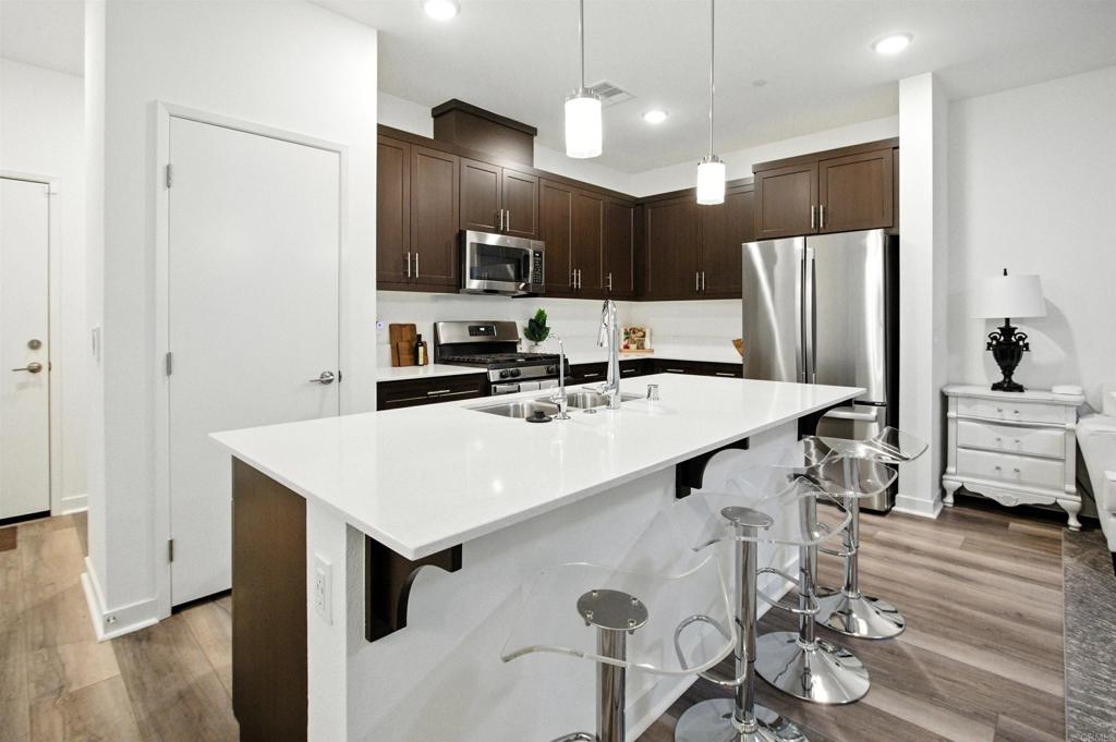 332 Seedling Way Fallbrook, CA 92028 - Photo 2 of 37 a kitchen with a sink a refrigerator and chairs