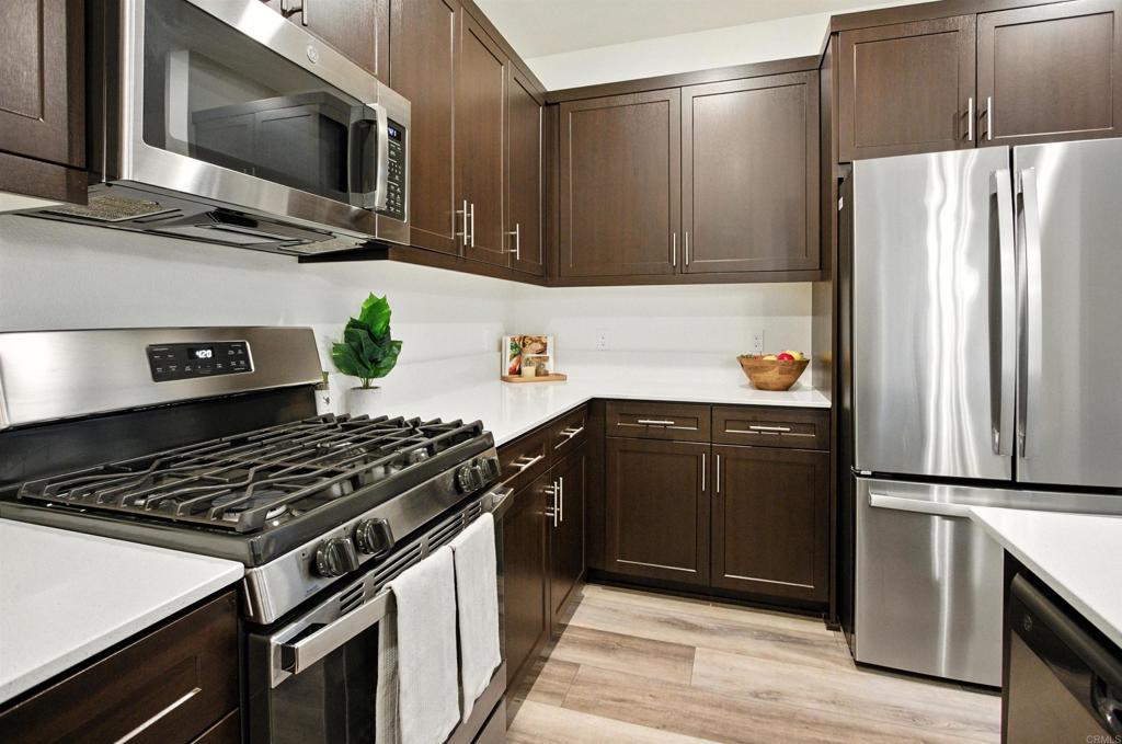 332 Seedling Way Fallbrook, CA 92028 - Photo 4 of 37 a kitchen with granite countertop a refrigerator stove and microwave