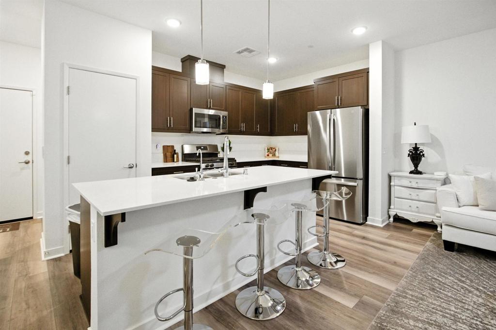 332 Seedling Way Fallbrook, CA 92028 - Photo 8 of 37 a kitchen with stainless steel appliances kitchen island a refrigerator sink and cabinets