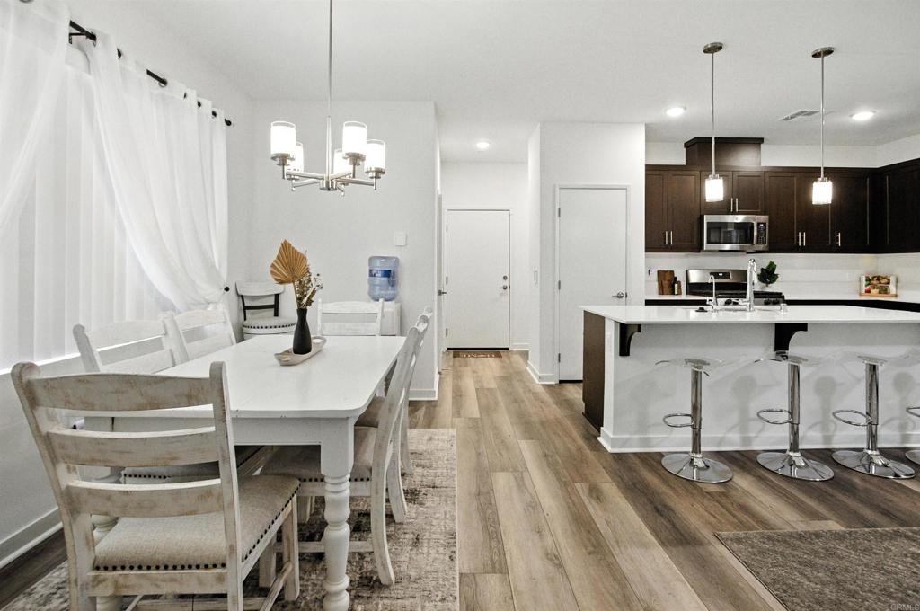 332 Seedling Way Fallbrook, CA 92028 - Photo 9 of 37 a kitchen with kitchen island a dining table chairs sink and cabinets