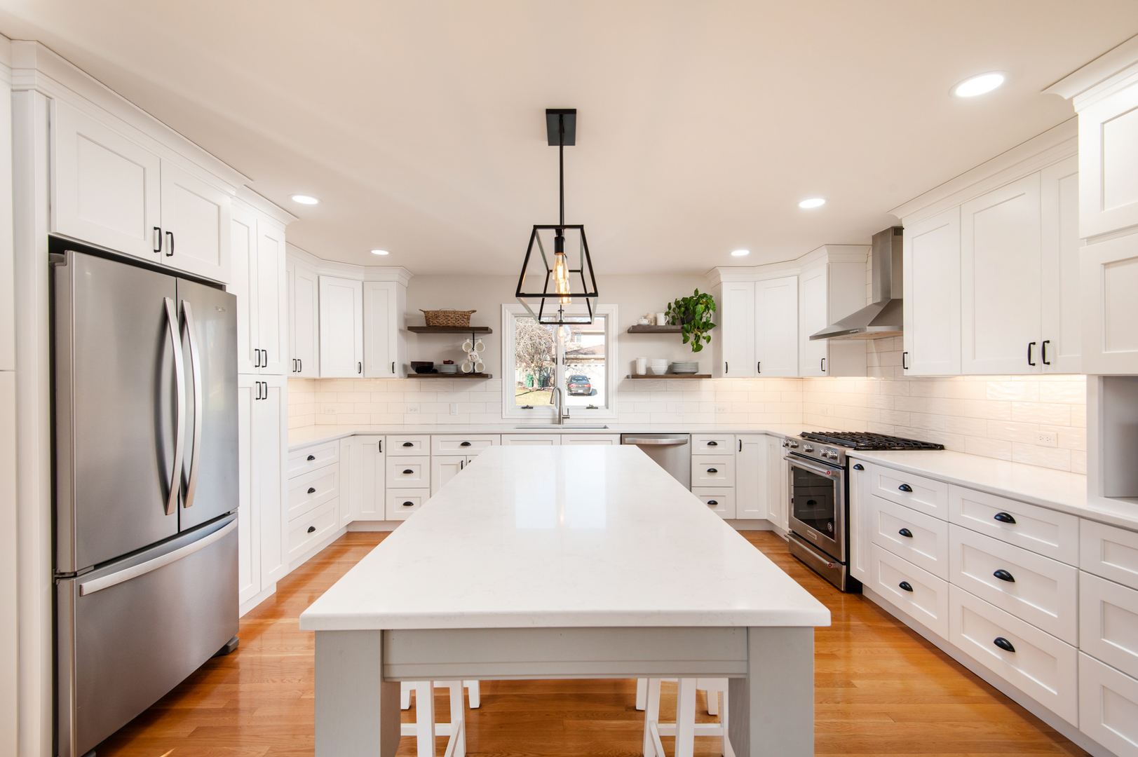 13530 South Monaghan Road Homer Glen, IL 60491 - Photo 12 of 45 a kitchen with stainless steel appliances kitchen island granite countertop a refrigerator a sink dishwasher a stove and white cabinets with wooden floor