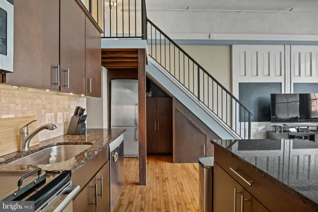 a kitchen with granite countertop a sink a stove and cabinets