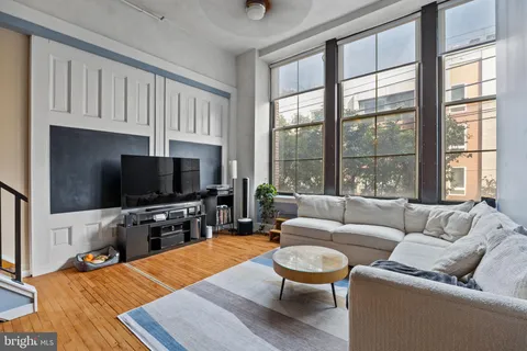 a living room with furniture a flat screen tv and a large window