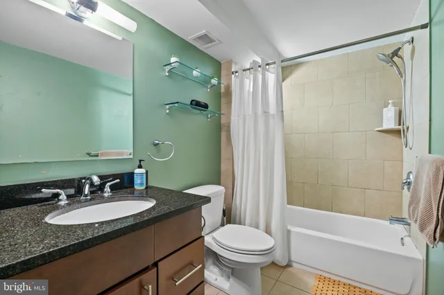a bathroom with a granite countertop sink toilet and shower