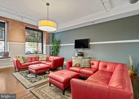 a living room with furniture a flat screen tv and a large window