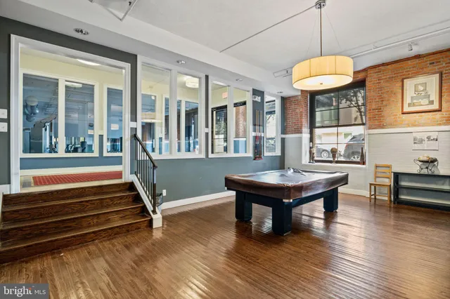 a room with wooden floors and pool table