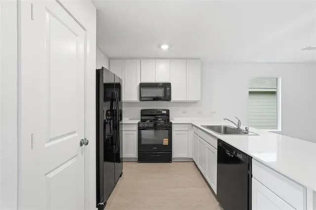 a kitchen with a sink a stove and microwave