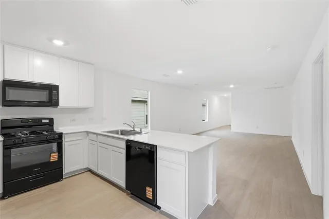 a view of a kitchen with refrigerator and windows