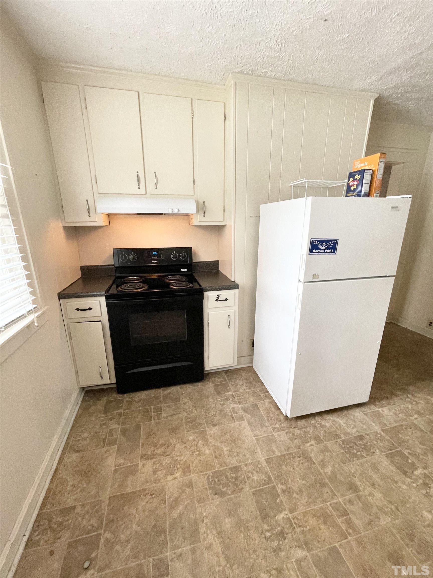 1005 Anderson Street Northwest Wilson, NC 27893 - Photo 6 of 16 a kitchen with a stove and a refrigerator