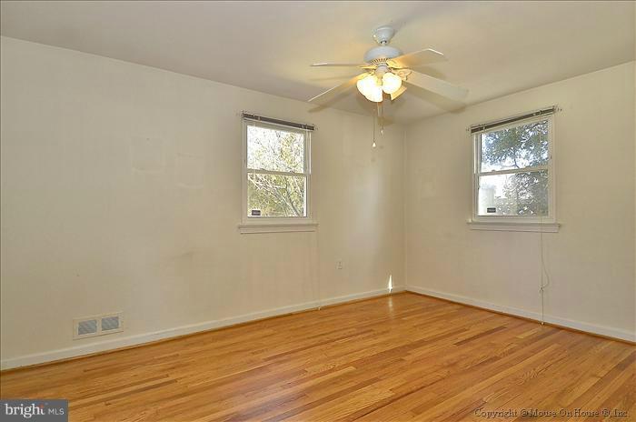 1005 Forest Glen Road Silver Spring, MD 20901 - Photo 12 of 26 a view of an empty room with wooden floor and a window
