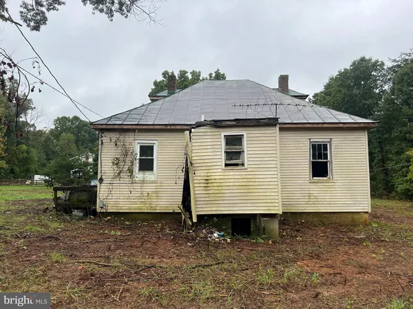 a view of a small white house and a yard