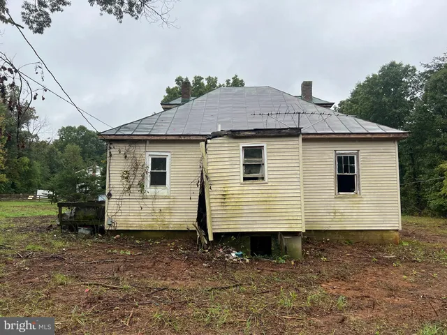 a view of a small white house and a yard