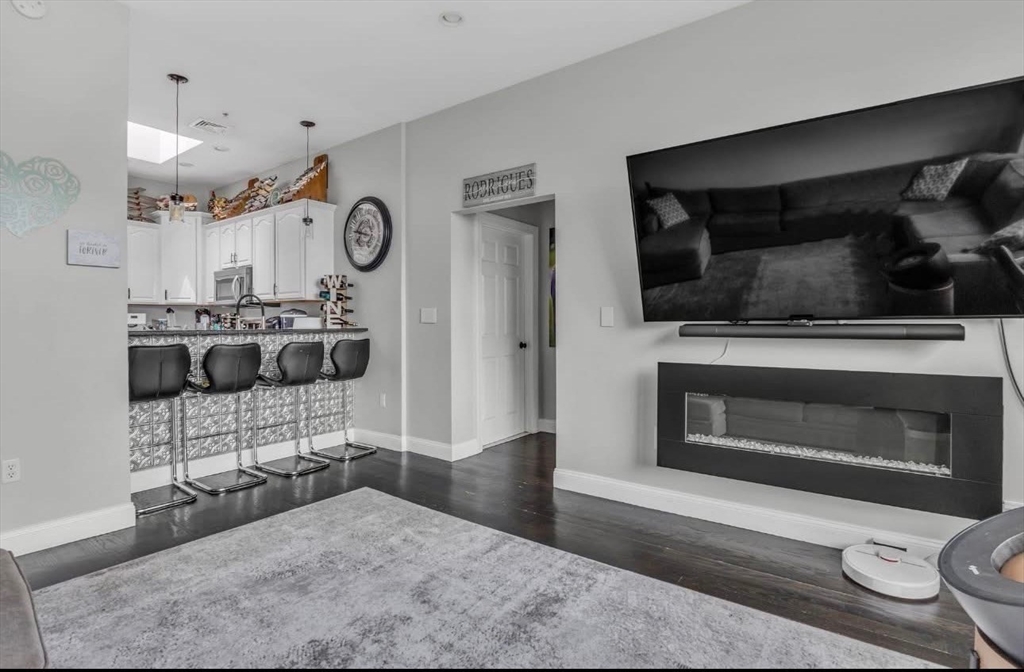 a living room with furniture a flat screen tv and kitchen view