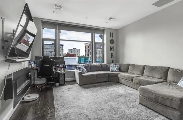 a living room with furniture and a floor to ceiling window
