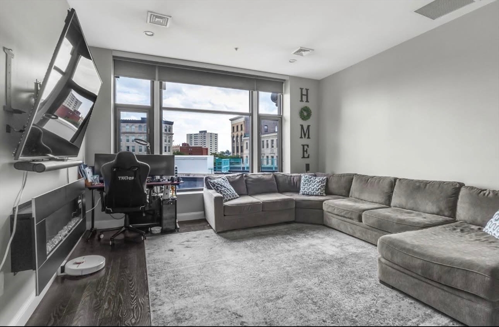 7 Central Square, Unit 307 Lynn, MA 01901 - Photo 1 of 9 a living room with furniture and a floor to ceiling window